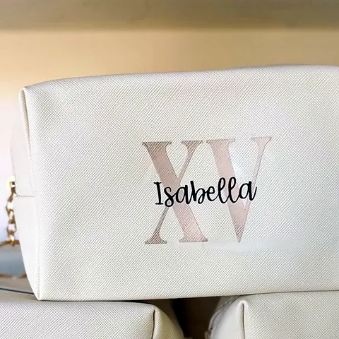 Stack of cream makeup pouches personalized with a rose-gold XV monogram and the name Isabella